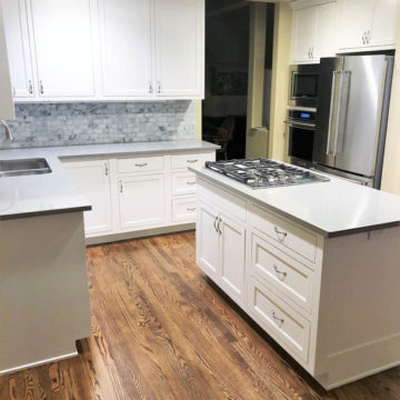 Completed kitchen with custom built cabinets, quartz countertops, tile backsplash, refinished and stained hardwood floors, and new appliances