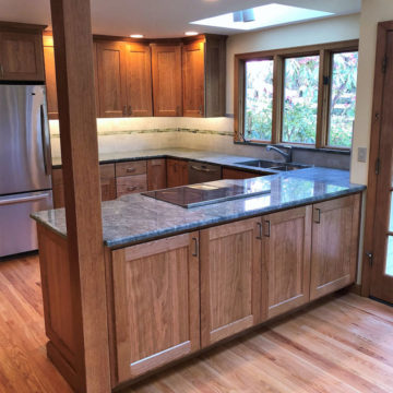 Completed kitchen with new custom built cabinets, granite counters, tile backsplash, under cabinet lighting, and refinished wood floors