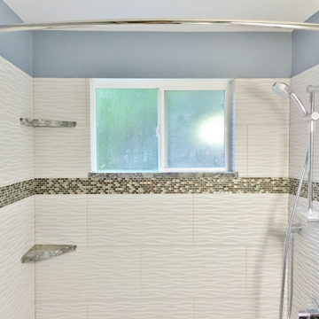 Completed shower with new tile walls shower hardware and matching quartz shelves and window sill