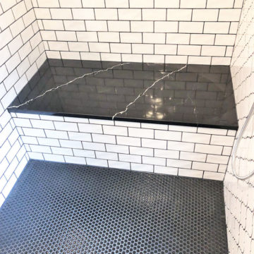Custom quartz shower bench with tile floor and surround