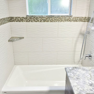 New bath tub with tile surround and matching quartz shelves and window sill