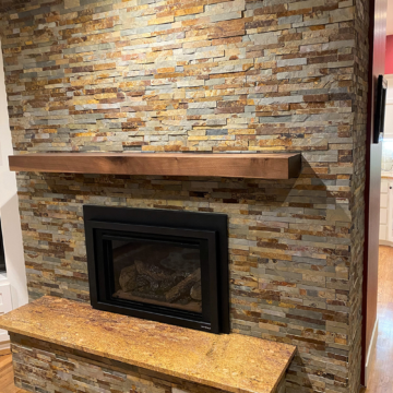 Completed fireplace remodel with new Heat n Glo fireplace insert stacked stone custom walnut mantel