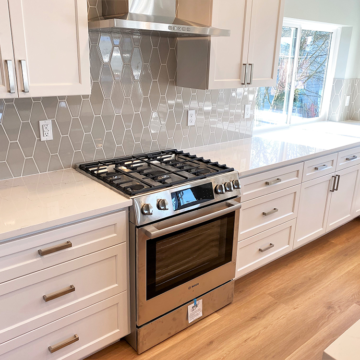 Completed kitchen wall removed custom cabinets quartz countertops tile backsplash, new windows