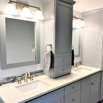 A newly enlarged bathroom with custom double vanity quartz counters tile backsplash