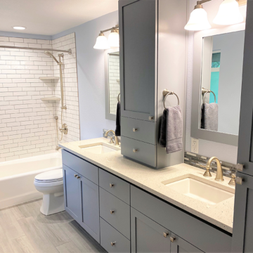 Newly enlarged bathroom custom double vanity quartz counters new tub tile surround quartz shelves tile flooring