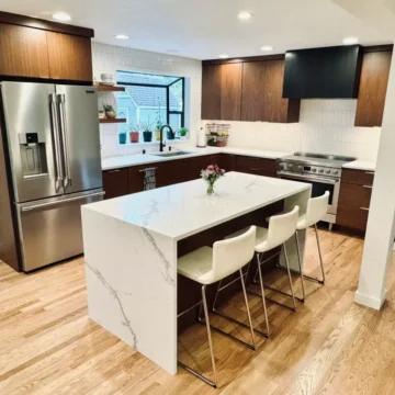 Finished kitchen with opened wall, custom cabinets, quartz counters, and tile backsplash